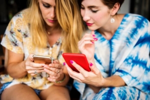 Two women on their iPhones